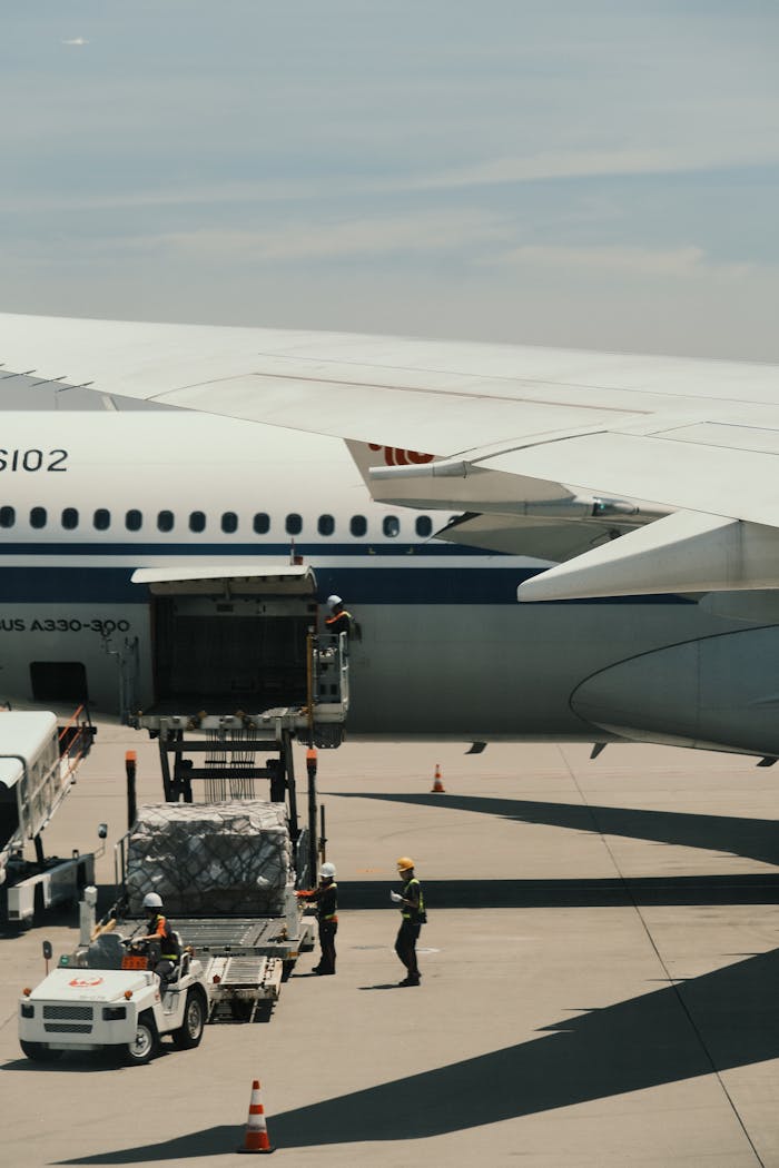 Airbus A330 being loaded with cargo on an airport runway, showcasing transportation logistics.